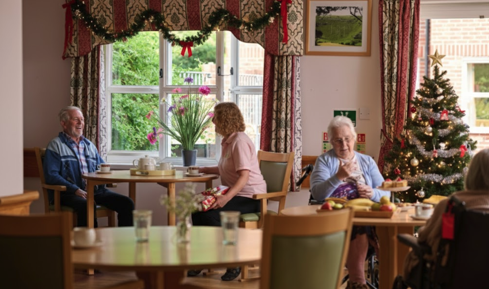 dining room in derwent lodge with a christmas tree and happy residents