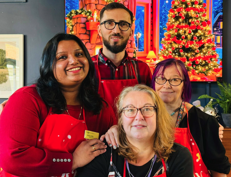 staff dressed festive in front of the christmas tree