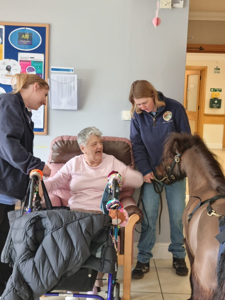 happy care resident petting pony (1)